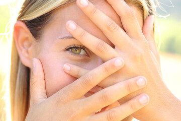 Timid teen hiding behind her hands