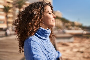 Young hispanic woman smiling confident breathing at seaside