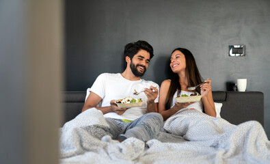 Romantic happy couple in love having breakfast in bed - obrazy, fototapety, plakaty