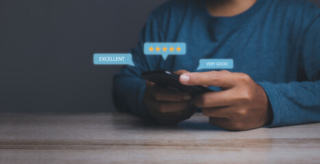 Businessman using mobile phone giving high score with five golden stars rating satisfaction in service.
