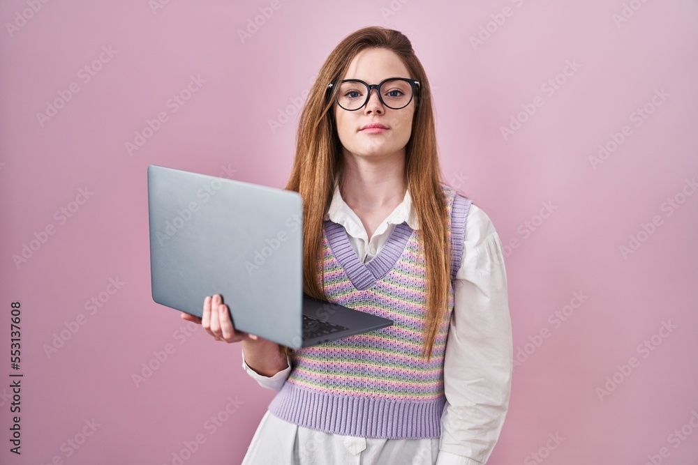 Canvas Prints Young caucasian woman working using computer laptop relaxed with serious expression on face. simple and natural looking at the camera.