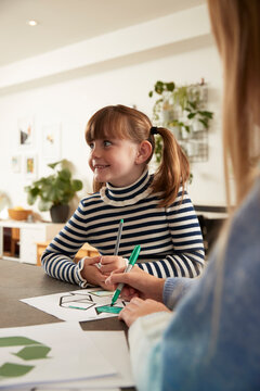 Happy Girl With Sister Coloring Recycling Symbol With Pen At Home