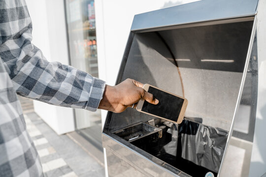 Man trashing smart phone in dustbin