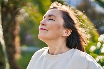 Middle age woman smiling confident breathing at park