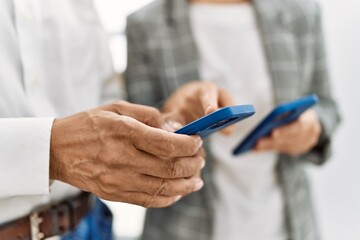 Middle age man and woman business workers using smartphone at office