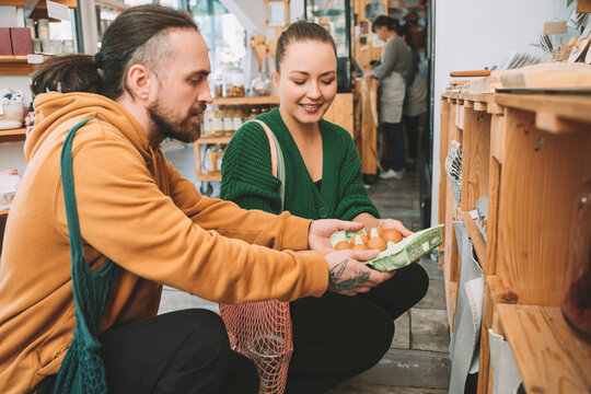 Couple holding egg carton in convenience store