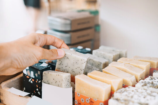 Woman picking scented soap bar at zero waste shop