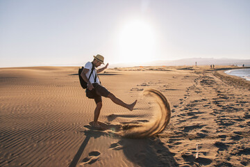Man playing with sand at beach on sunset