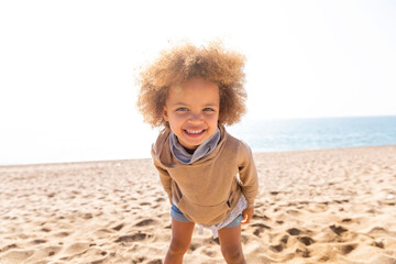 Happy cute girl with Afro hairstyle standing at beach
