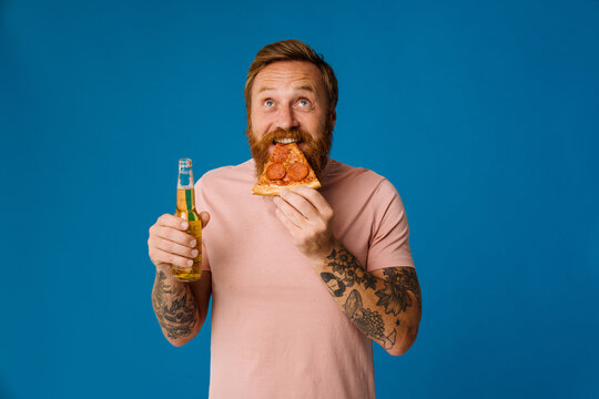 Bearded Happy Man Holding Pizza Slice And Beer While Standing Isolated