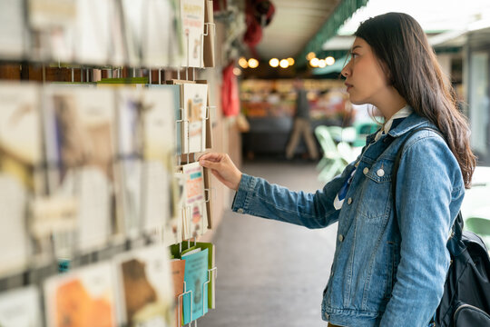 Asian Korean girls buy postcards at street souvenir shops and send them to their families during their trip to Los Angeles.