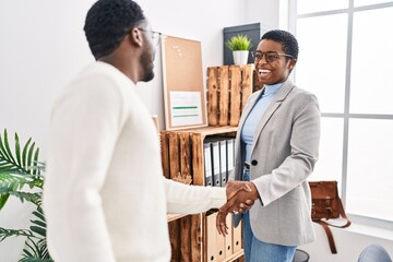 Man and woman business workers shake hands at office