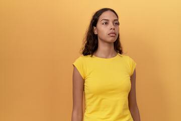 Obraz premium Young african american woman standing with serious expression over isolated yellow background
