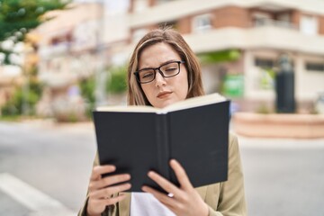 Young woman business worker reading book at street