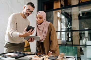 Two multiracial colleagues designers working together in modern office
