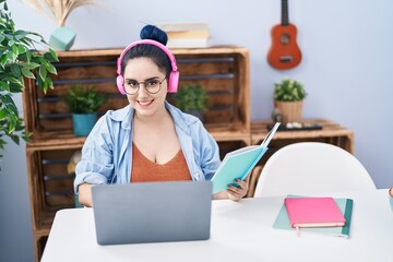 Young caucasian woman sitting on table studying at home