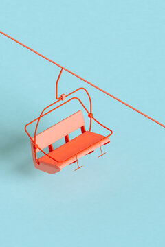 Three dimensional render of red ski lift floating against blue background