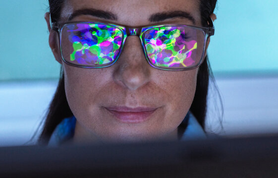 Reflection of molecular structure on scientist's eyeglasses in laboratory