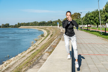 Young self loved teenage girl fitness exercises outdoor as morning routine for self-awareness of healthy life. Good posture woman stretching her muscles before workout training.