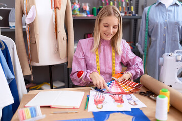 Young blonde woman tailor smiling confident holding color test at tailor shop