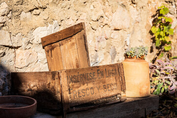 wooden crate against stone wall in sunshine