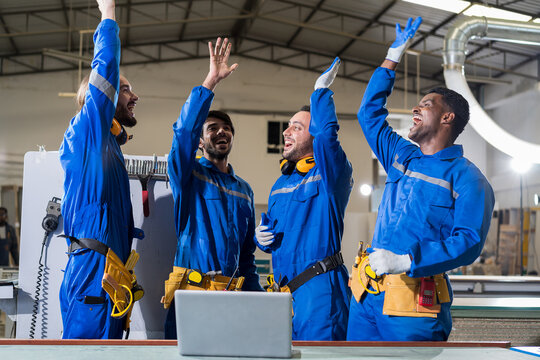 Group of male technician workers working and holding hands together in the industry factory. Team of male engineer workers in safety uniform and equipment tool working in the workplace factory