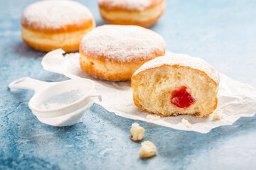 German donuts - berliner filled with strawberry jam with icing sugar
