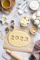 Homemade cookie dough in the form of numbers 2023. The concept of baking for New Year and Christmas.