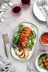 Porchetta, a delicious pork roast wrapped in a roll. Traditional Italian dish for holidays on a gray concrete background