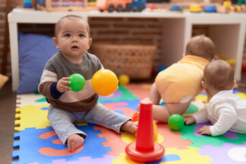 Group of toddlers playing with toys crawling on floor at kindergarten