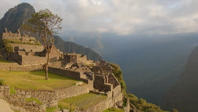 zoom out machu picchu historical Inca empire unesco seven wonder off the world sunrise warm light over andes mountains landscape