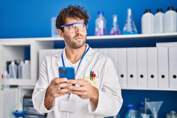 Young man scientist using smartphone at laboratory