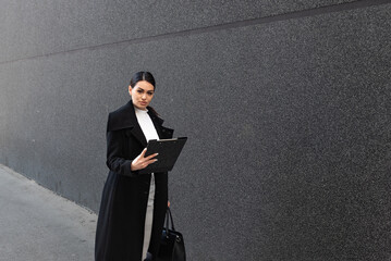 Young female defense attorney or prosecutor reads and checks the case as she walks toward the...