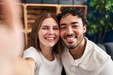 Obraz premium Man and woman hugging each other make selfie by the smartphone at home