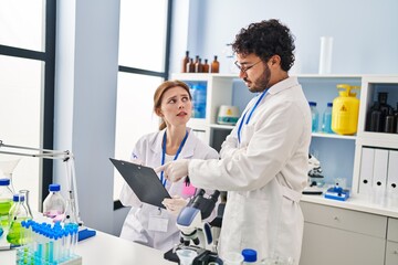 Fototapeta premium Man and woman scientist partners working at laboratory