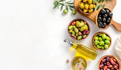  Different olives in bowls on white concrete background. Top view of olives, olive leaves and bottle of olive oil. Diet food concept. Banner. © Tatyana Sidyukova