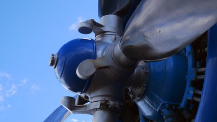 Shot close up, silver propellers of blue plane against clear sky. Aircraft turbine with propeller and silver blades. Light gray engine blades of airplane. Aircraft screw engines. Aerodynamic aircraft.