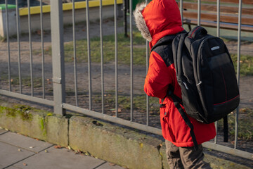 Boy goes to school with backpack on his back.