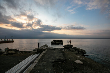Fototapeta na wymiar Sports embankment of Vladivostok. Broken pier going into the sea during sunset.
