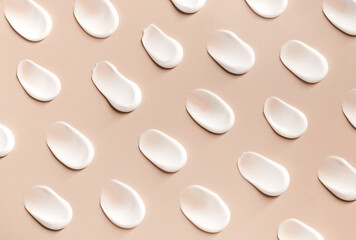 cosmetic smears of creamy texture on a beige background