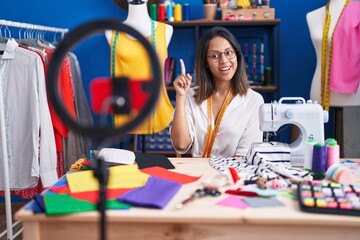 Hispanic young tailor woman recording video tutorial with smartphone smiling with an idea or question pointing finger up with happy face, number one