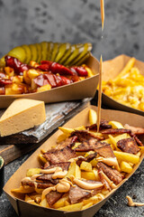 Traditional fast and street food, French fried potatoes with beef stew and mayonnaise in paper box