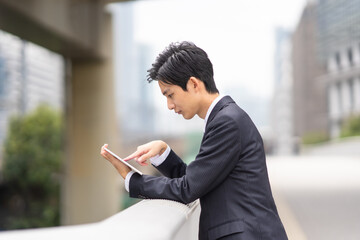 オフィス街でタブレットを持つビジネスマン