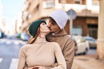 Mand and woman couple hugging each other and kissing at street