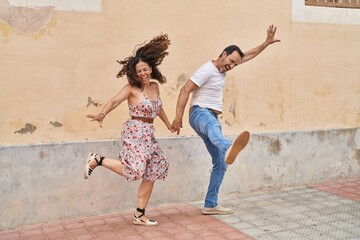 Fototapeta na wymiar Man and woman couple smiling confident dancing at street