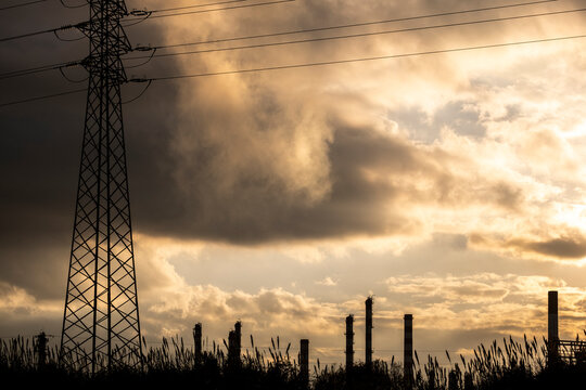 High voltage cable pylons in a dramatic cloudy sunset