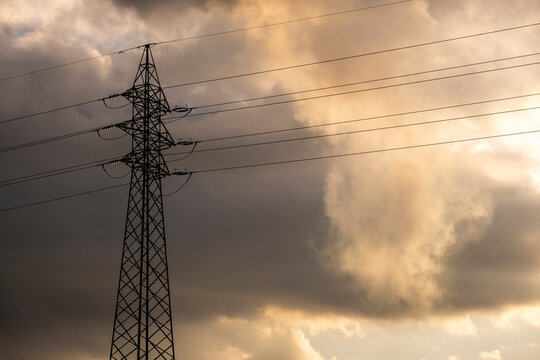 High voltage cable pylons in a dramatic cloudy sunset