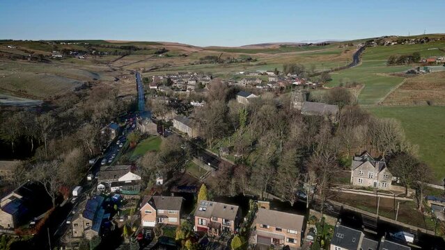 Aerial footage of the village of Denshaw, and the old church and graveyard, a typical rural village in the heart of the Pennines. Showing old houses roads. Situated in Oldham, England, UK