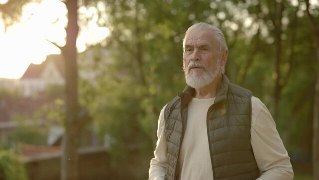 Mature man is jogging in the street. Elderly male running outside. Runner.Sport and healthy lifestyle concept. Aging youthfully. People and sport concept.