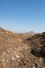 Dry riverbed in the Hajar Mountains of the United Arab Emirates with clear blue sky, UAE, rocky mountains with copy space